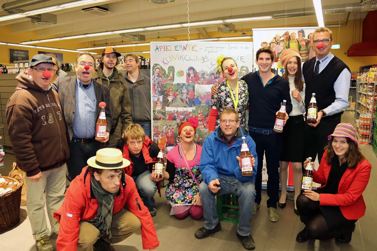 Präsentation des Lachsafts mit Klinikclowns und Unterstützern